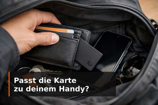 Trackerkaart in een zwarte portemonnee in een tas, met Duitse tekst over het controleren van de telefooncompatibiliteit.